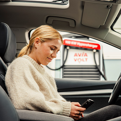 Frau lädt E-Auto